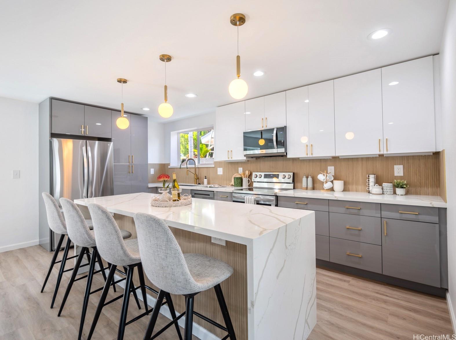 a kitchen with kitchen island granite countertop a sink a counter space appliances and cabinets