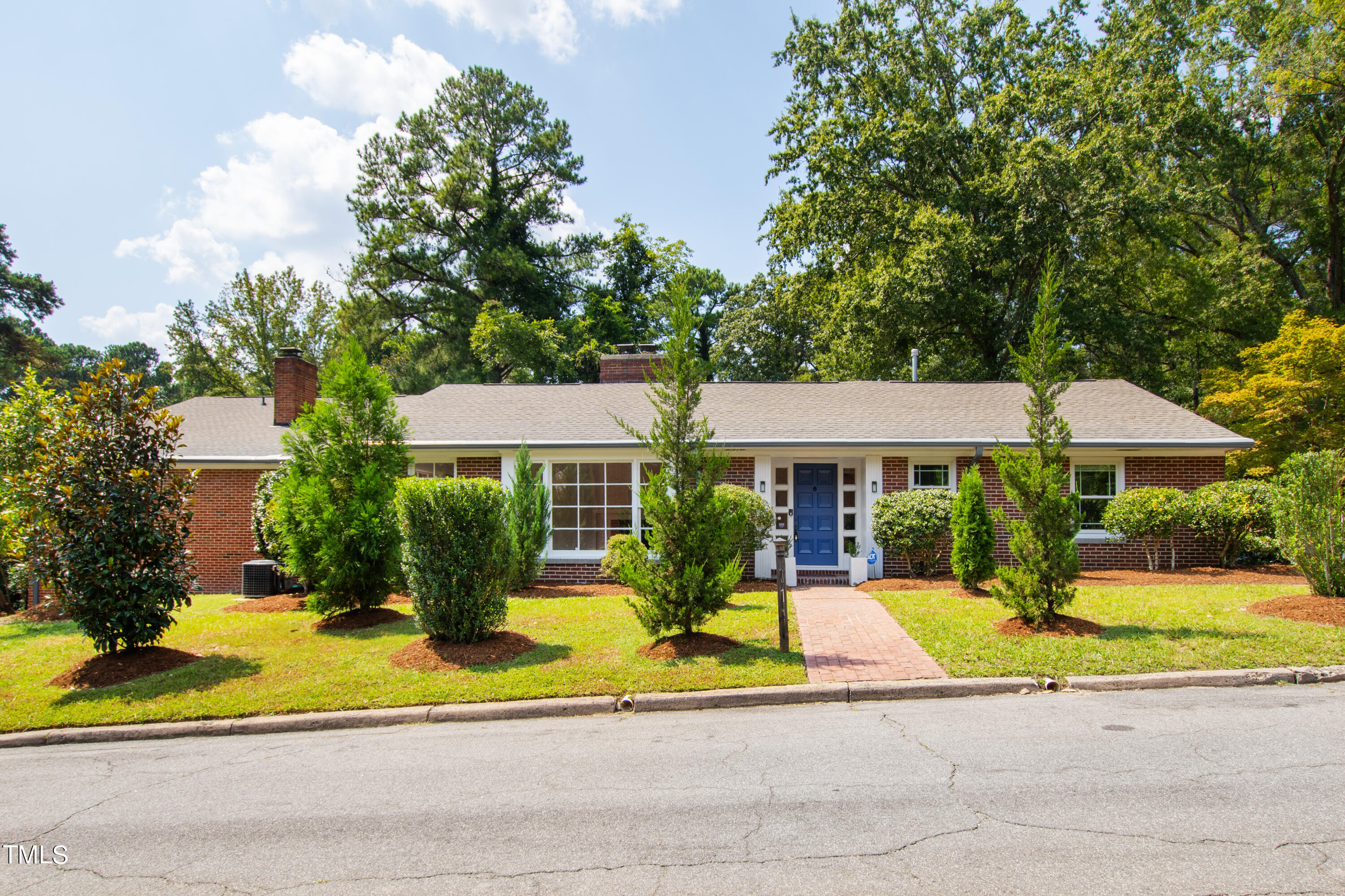 a view of house with outdoor space garden and tall trees