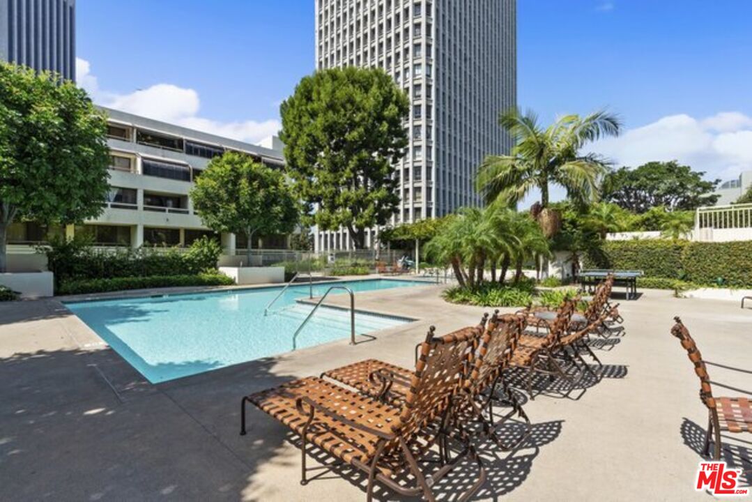 a view of a swimming pool with a patio and a yard