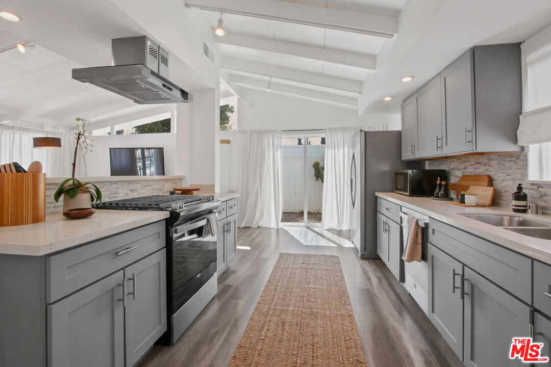 a kitchen with white cabinets sink and stainless steel appliances