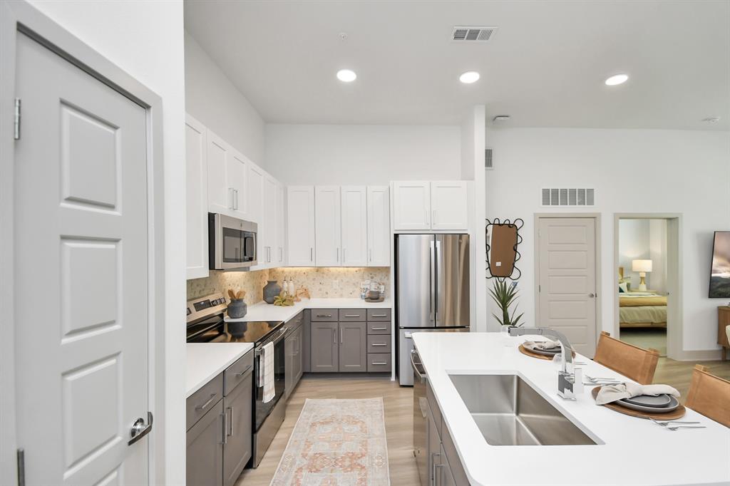 a kitchen with a refrigerator sink and cabinets