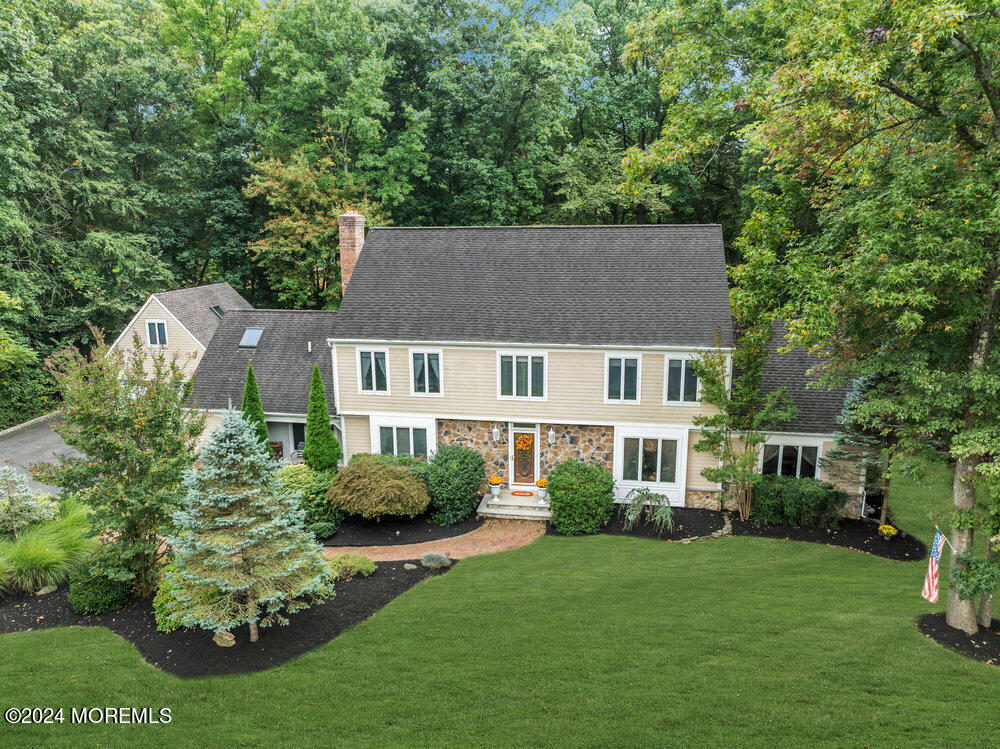 a aerial view of a house next to a big yard and large trees