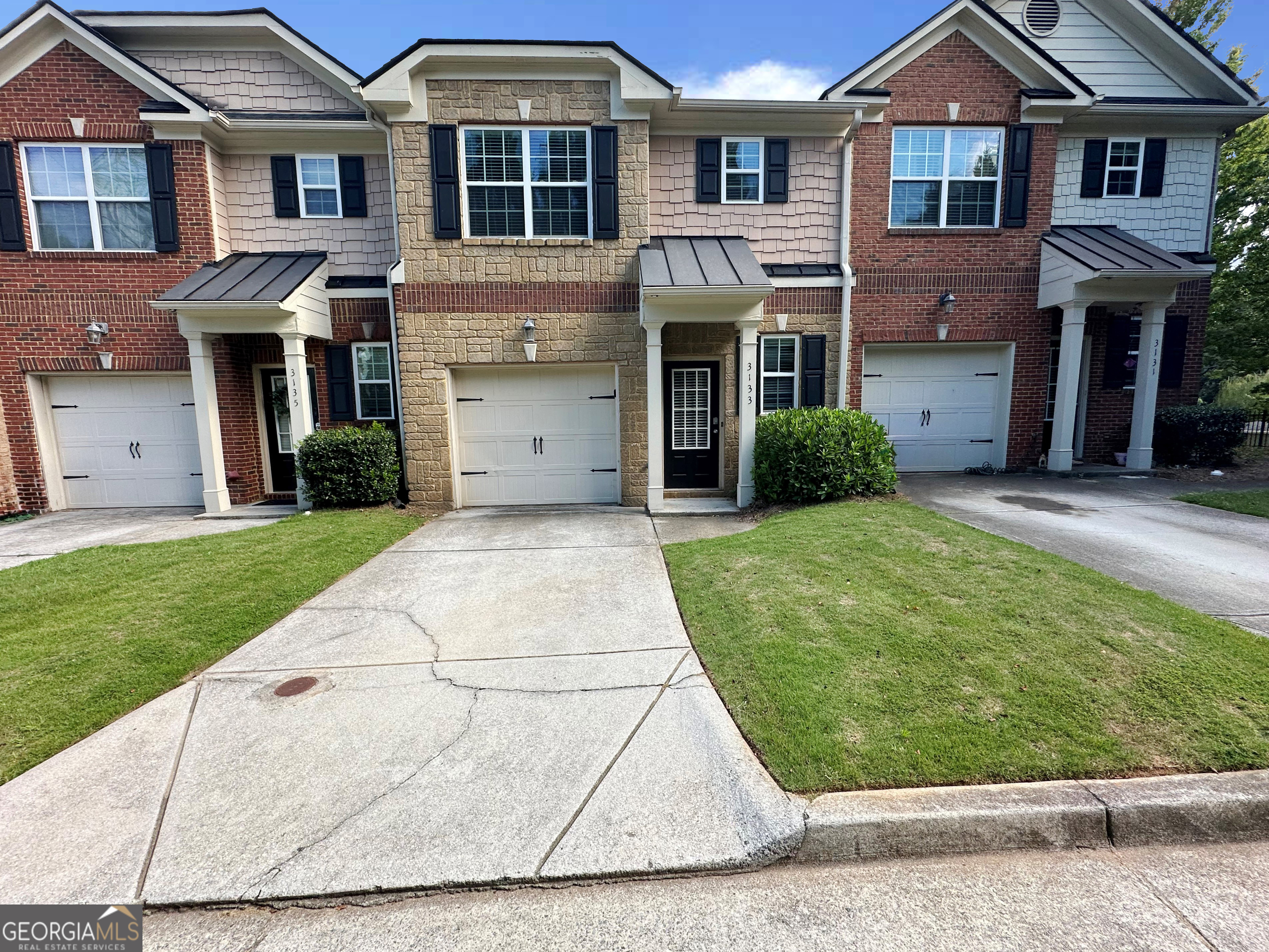 front view of a brick house with a yard