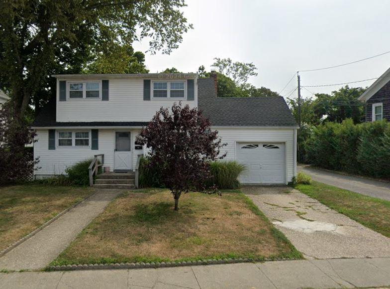 View of front of house with a garage and a front lawn