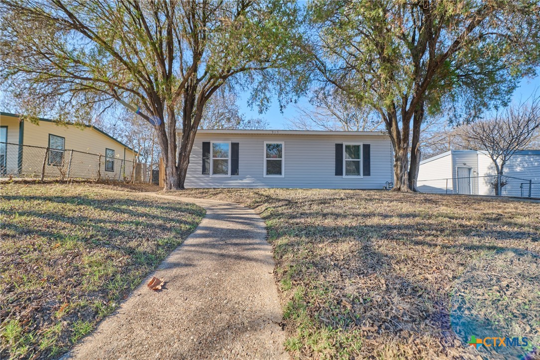 a front view of house with yard and trees around