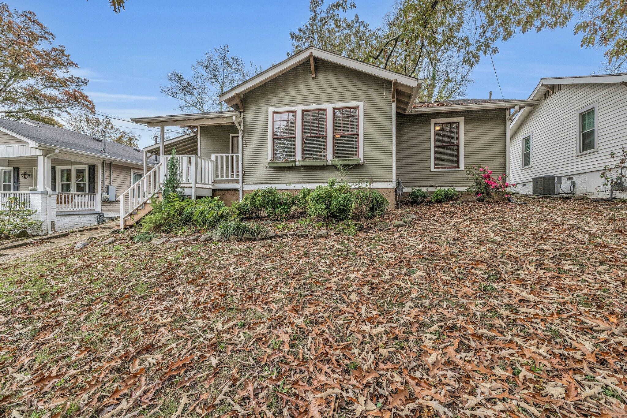 a view of a house with a yard and large tree