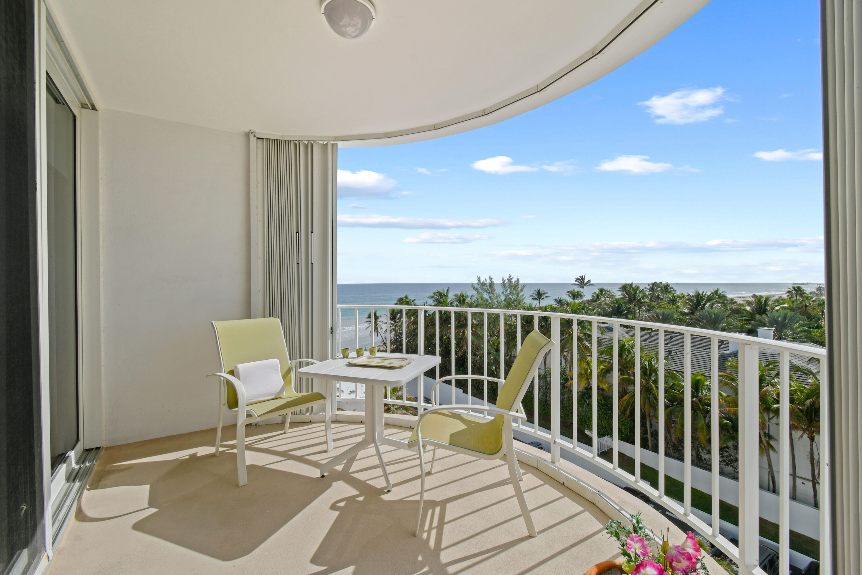 a balcony with wooden floor table and chairs