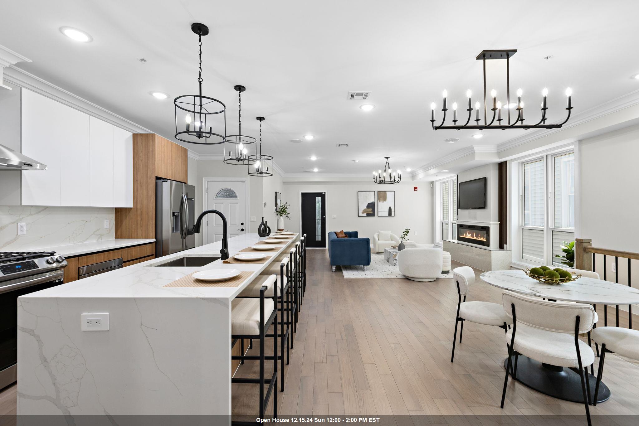 a view of a dining room and livingroom with furniture wooden floor a chandelier