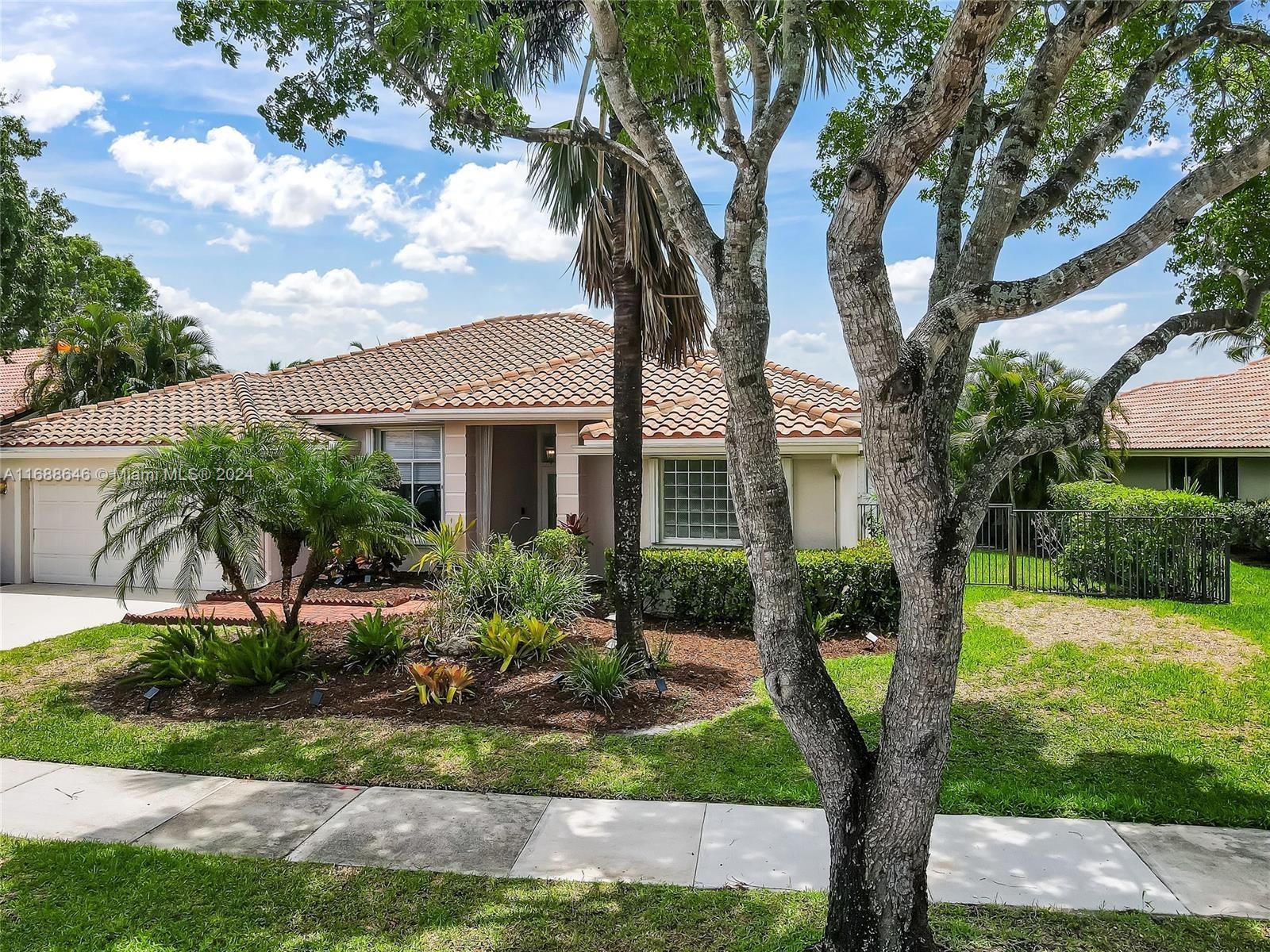 a front view of a house with a yard and fountain