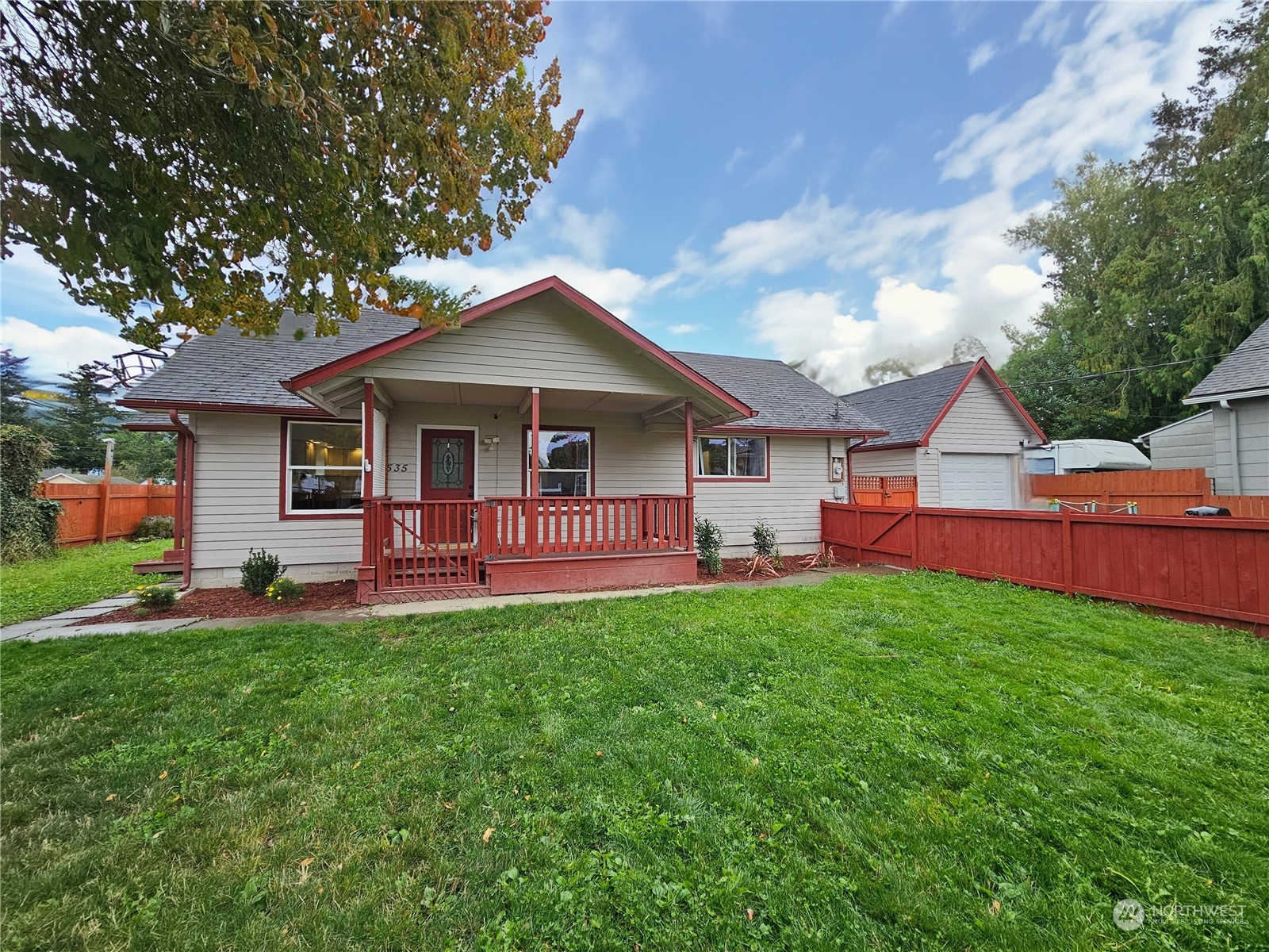 a front view of a house with a yard and trees