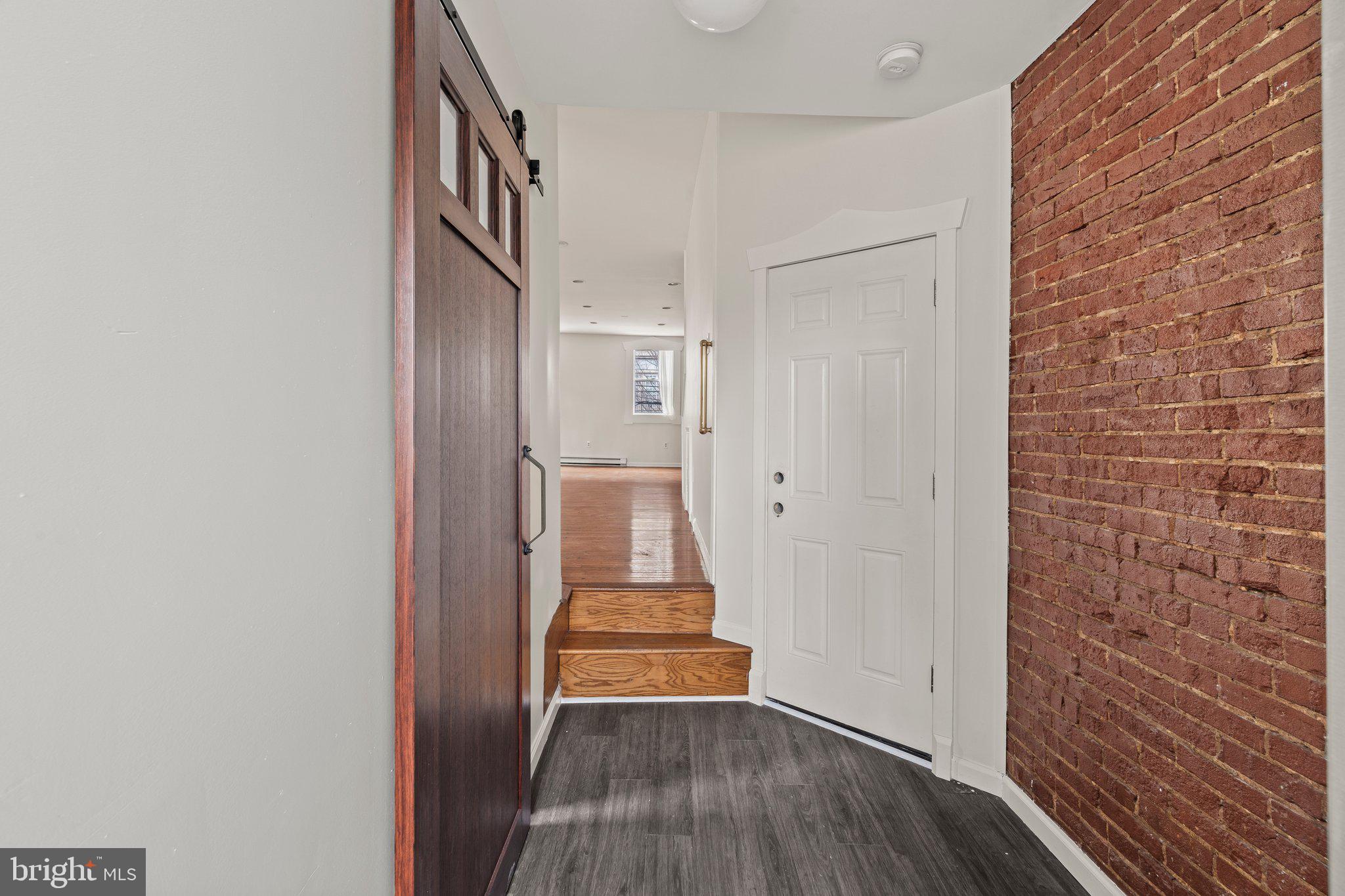 a view of a hallway with wooden floor and staircase