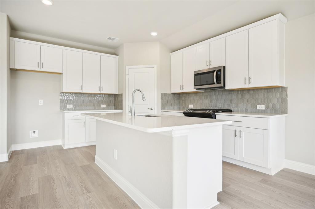 a kitchen with stainless steel appliances a sink a stove a refrigerator and cabinets