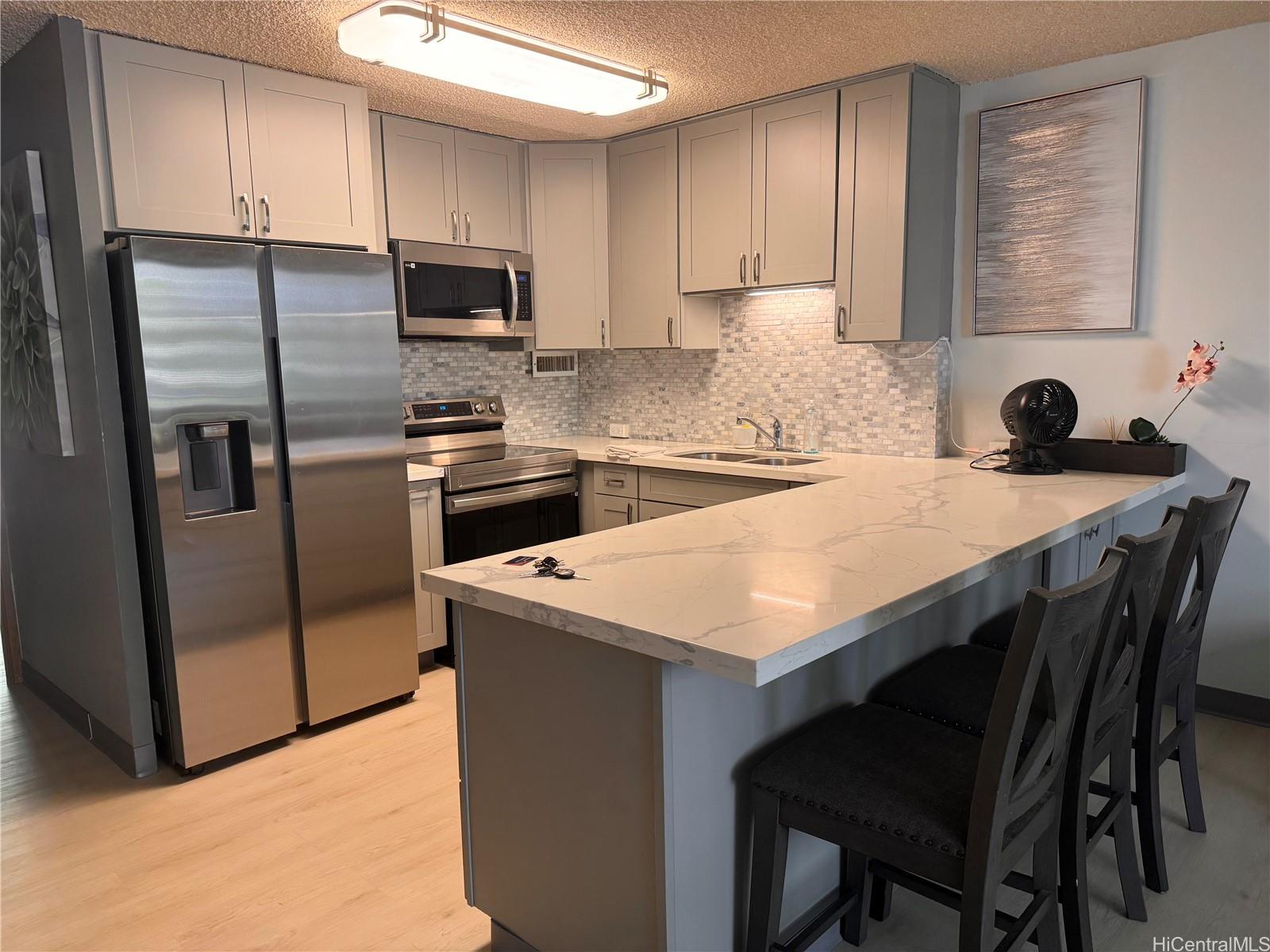 a kitchen with a stove a refrigerator and a sink