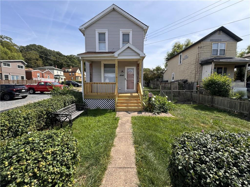 a front view of a house with a yard and potted plants