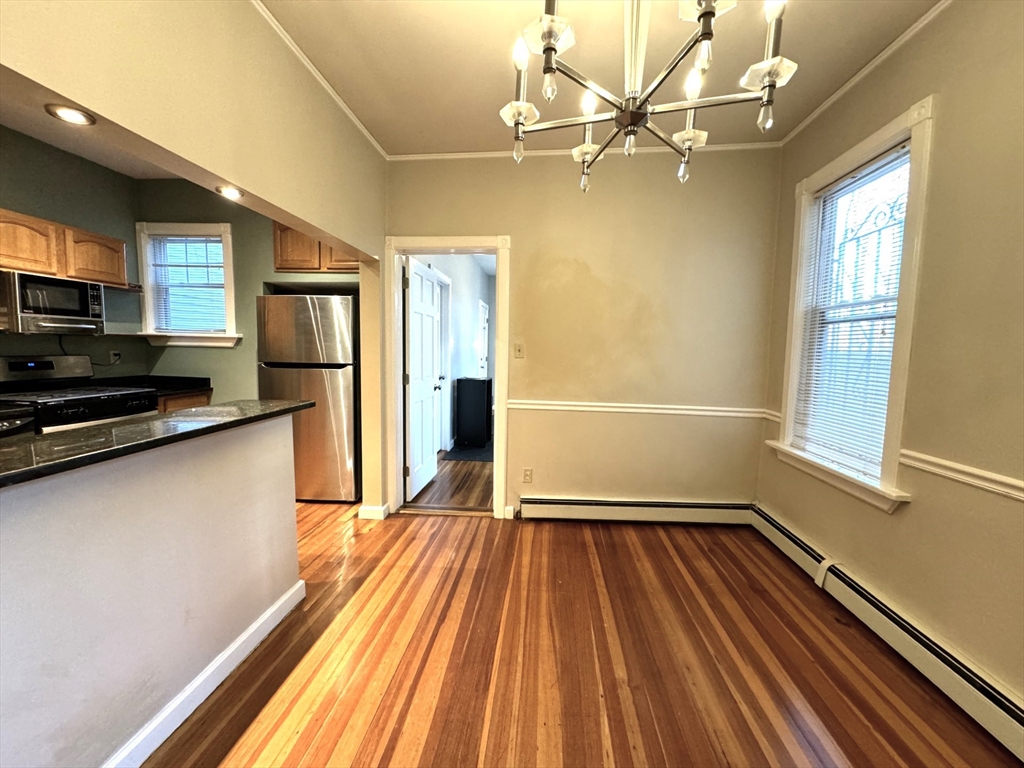 a view of a kitchen with wooden floor and a ceiling fan