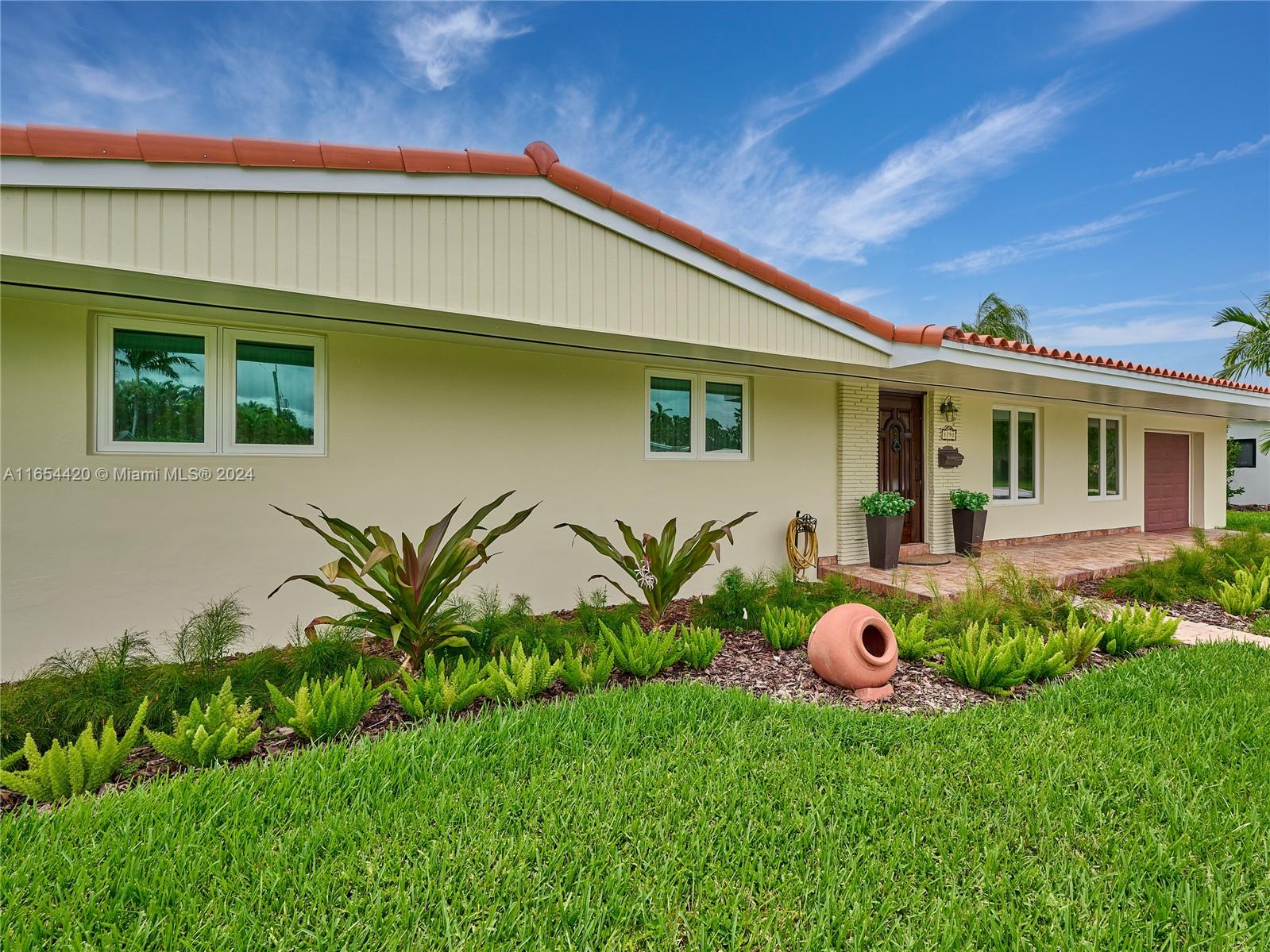 a front view of a house with a garden