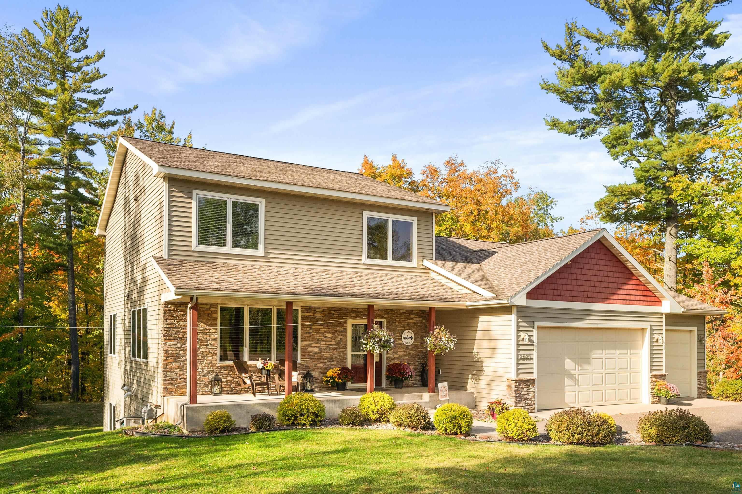 View of front of house with a front lawn, a porch, and a garage