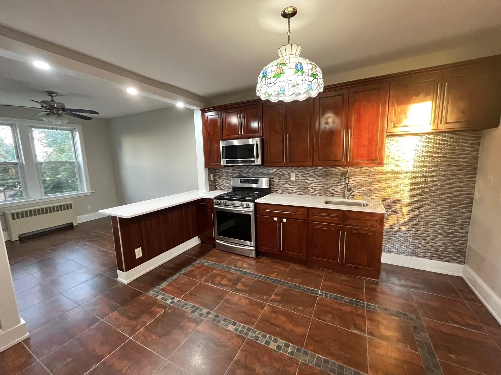 a kitchen with stainless steel appliances granite countertop a stove a sink dishwasher and a wooden cabinets