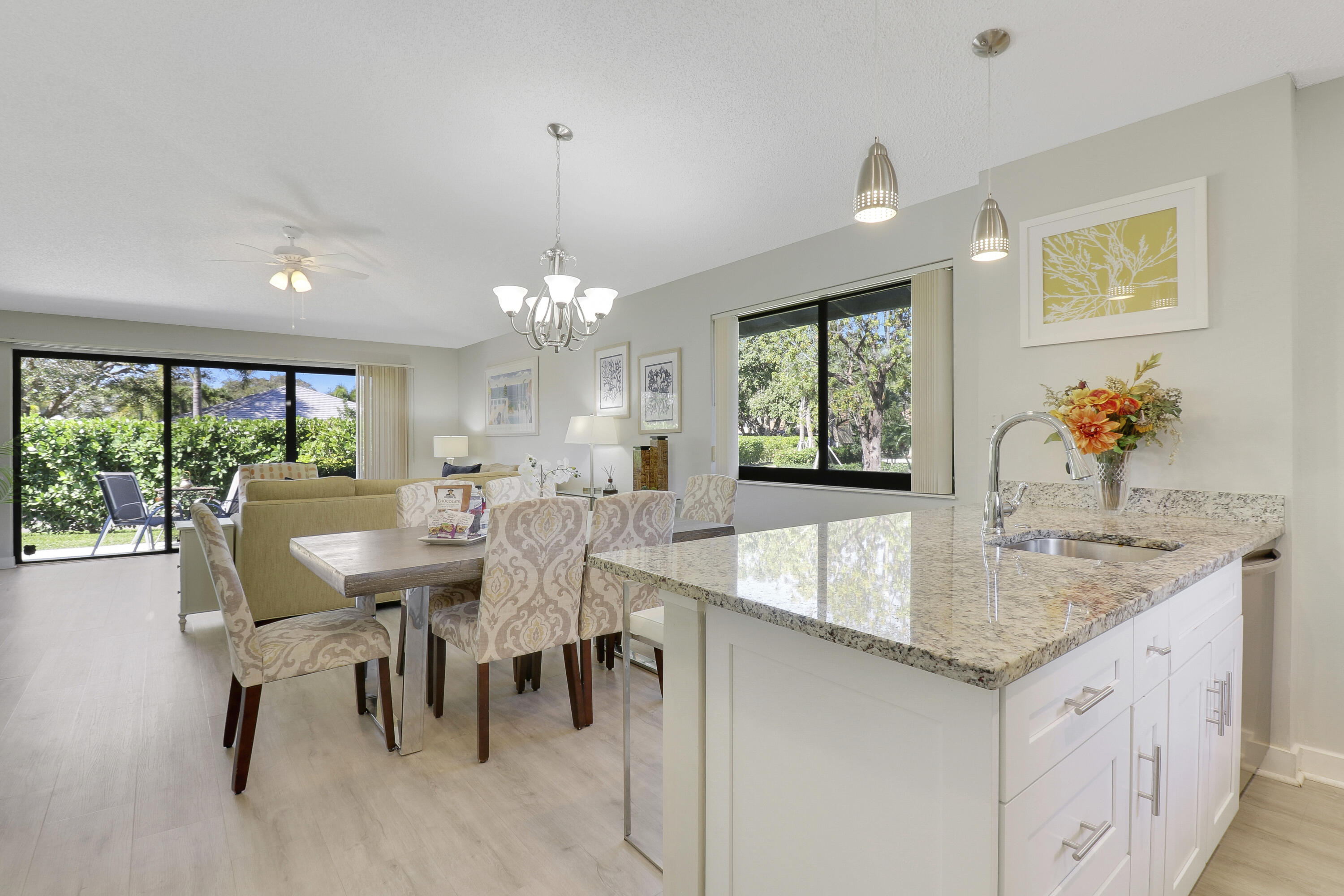 a view of a dining room with furniture a livingroom and chandelier