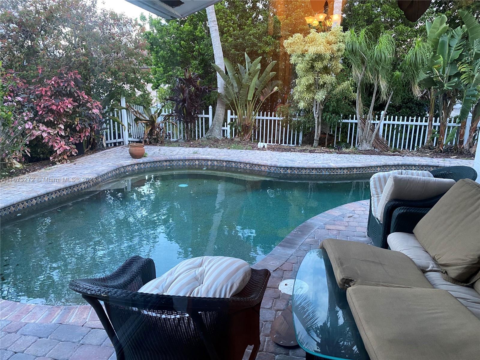 a view of backyard with swimming pool and outdoor seating