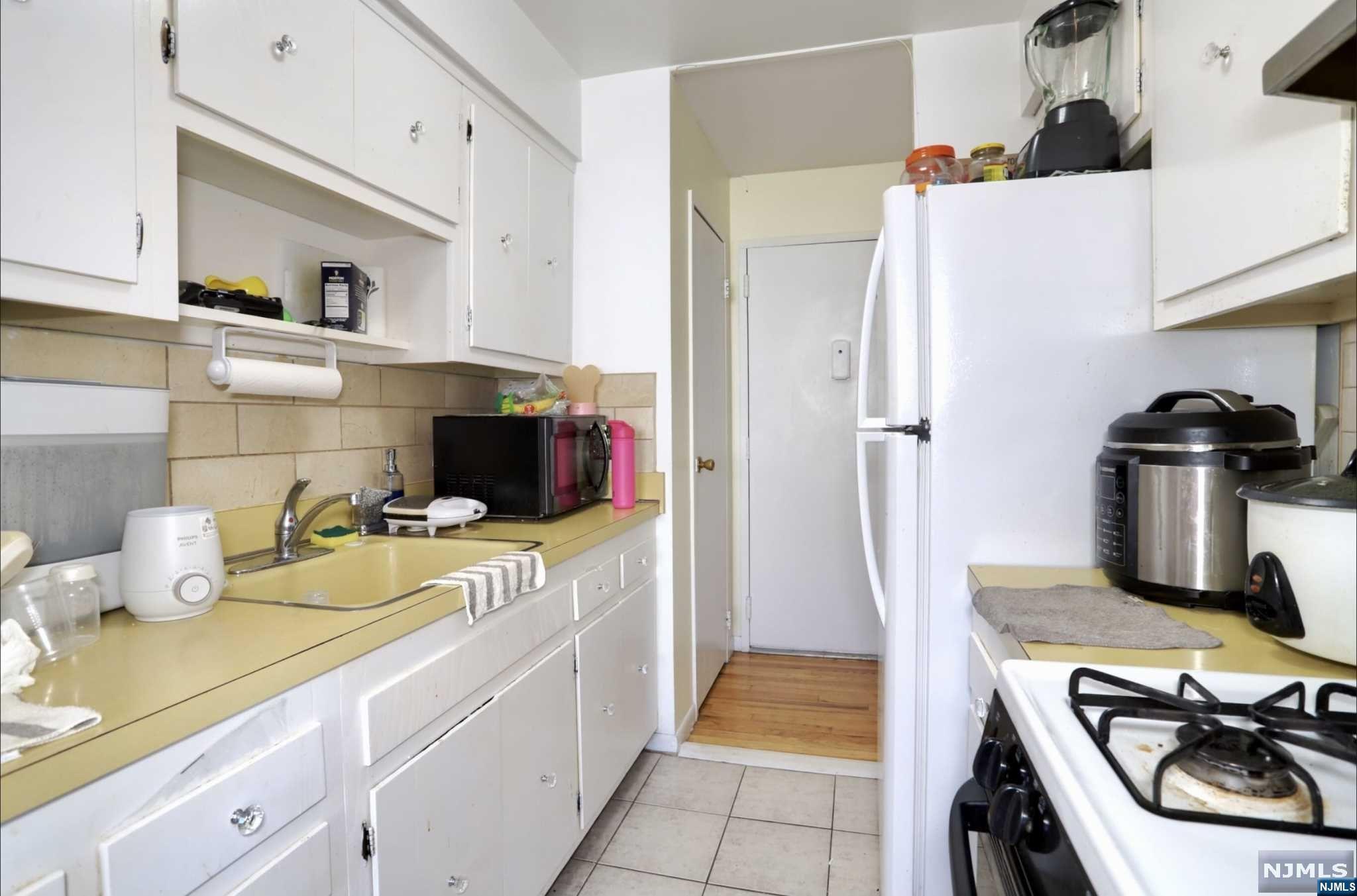 a kitchen with a sink and wooden floor