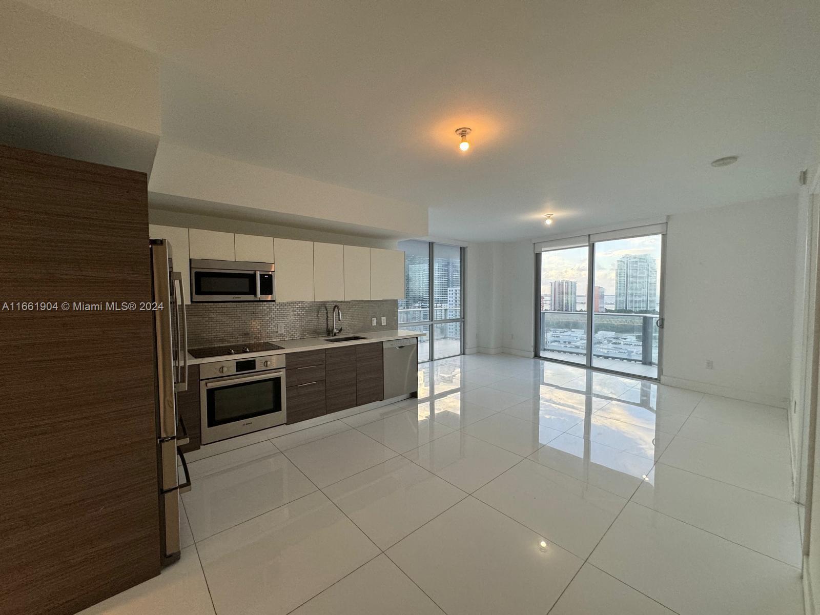 a large kitchen with a large counter top stainless steel appliances and cabinets