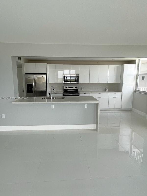 a view of a kitchen with a sink and cabinets