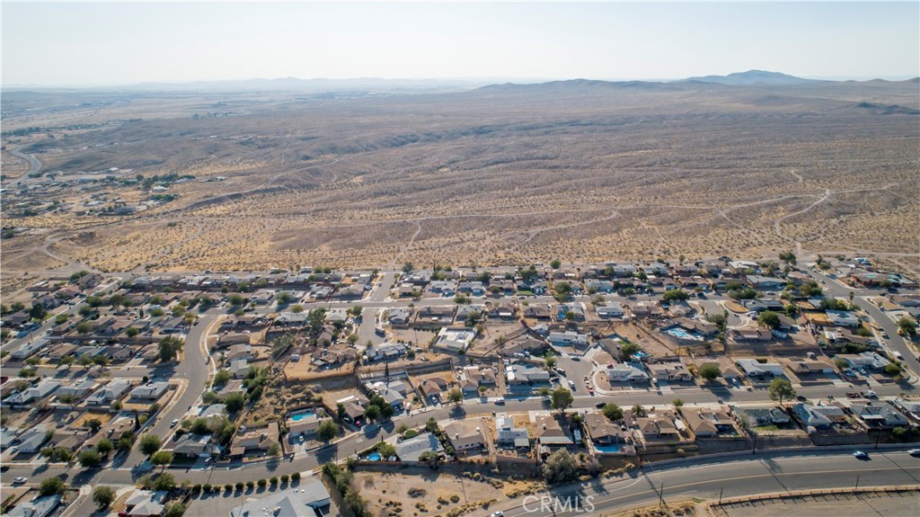 an aerial view of house with yard and mountain in the background