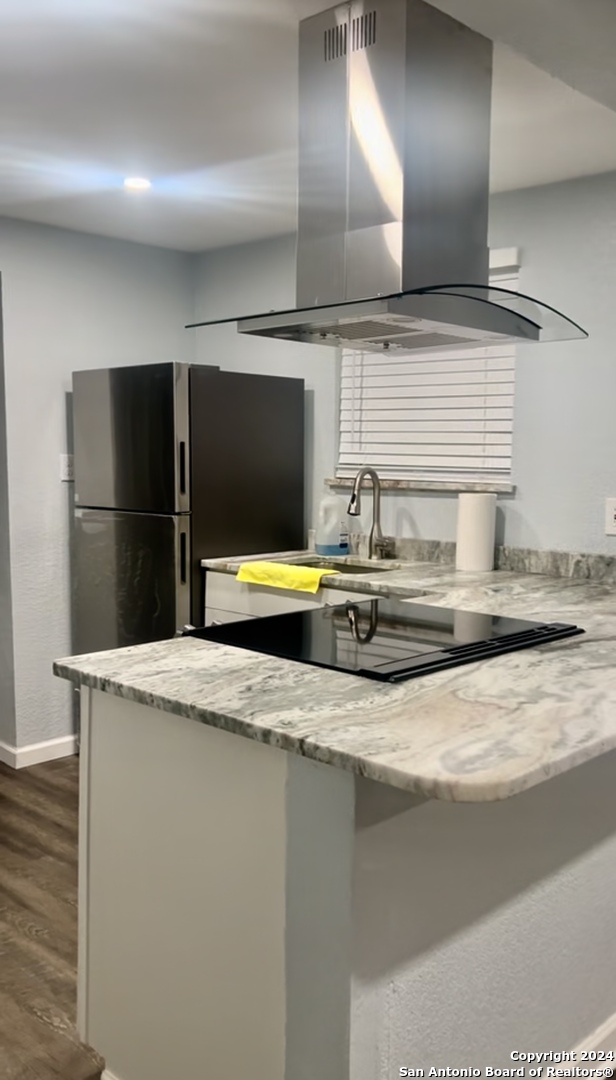 a kitchen with stainless steel appliances granite countertop a sink and a refrigerator