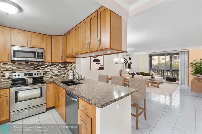 a kitchen with stainless steel appliances granite countertop a sink stove and cabinets