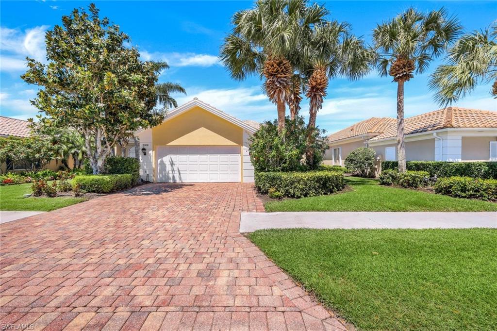 a front view of a house with a yard and palm trees