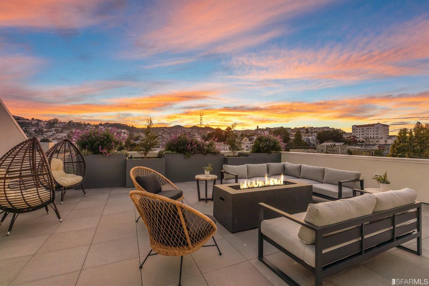 a view of a roof deck with couches and sky view