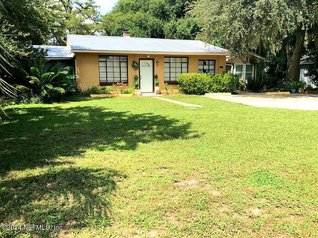 a front view of a house with yard and green space