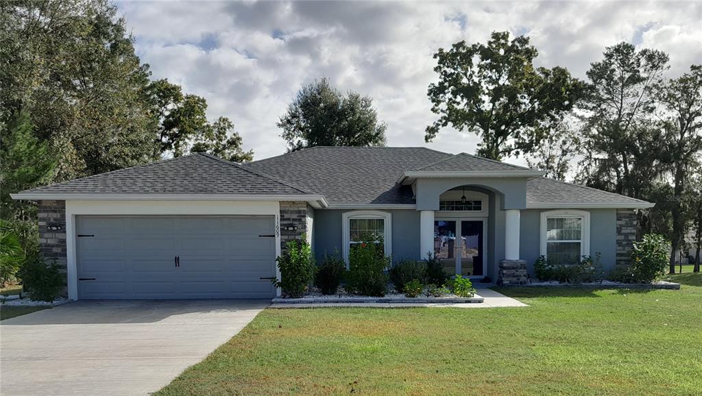 a front view of a house with a garden and yard