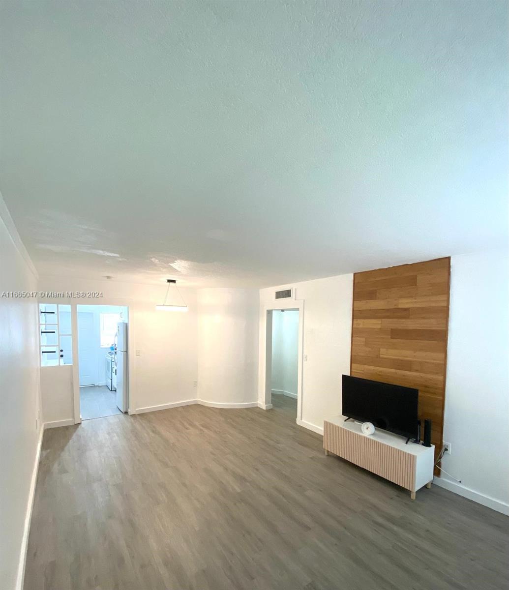 a view of empty room with wooden floor and fireplace