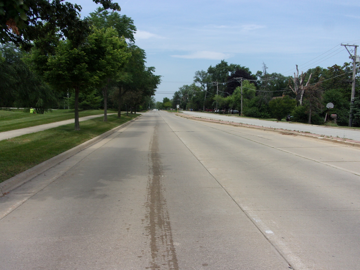 a view of a rural road with a building in the background