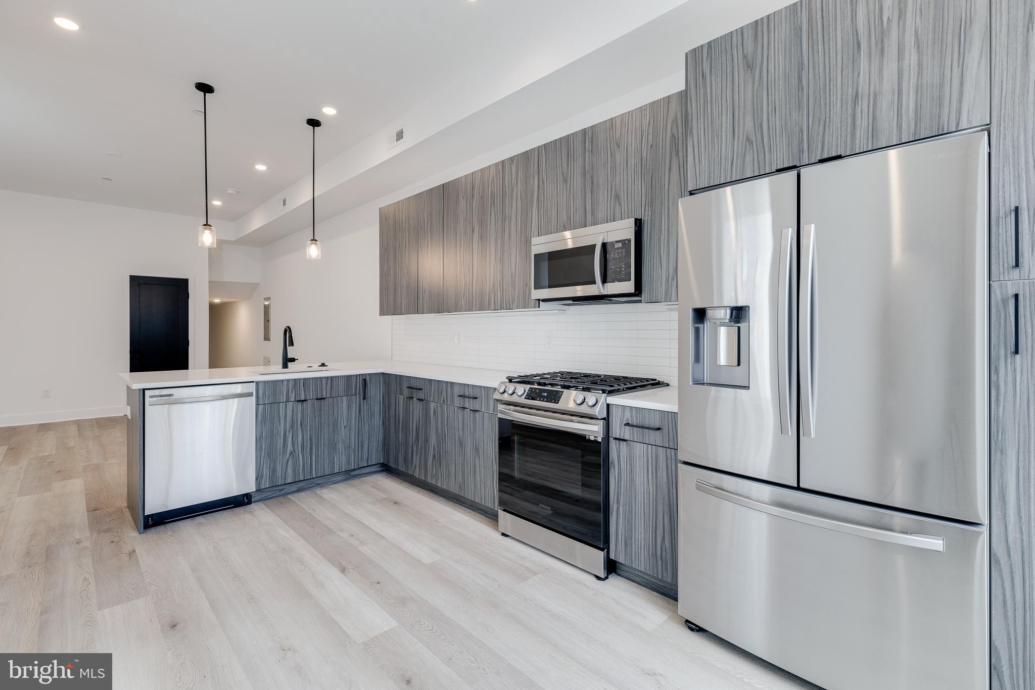 a kitchen with stainless steel appliances a refrigerator sink and microwave