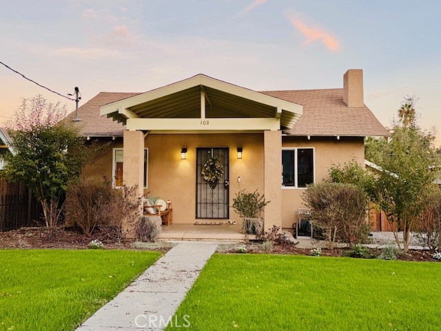 a front view of house with yard and outdoor seating