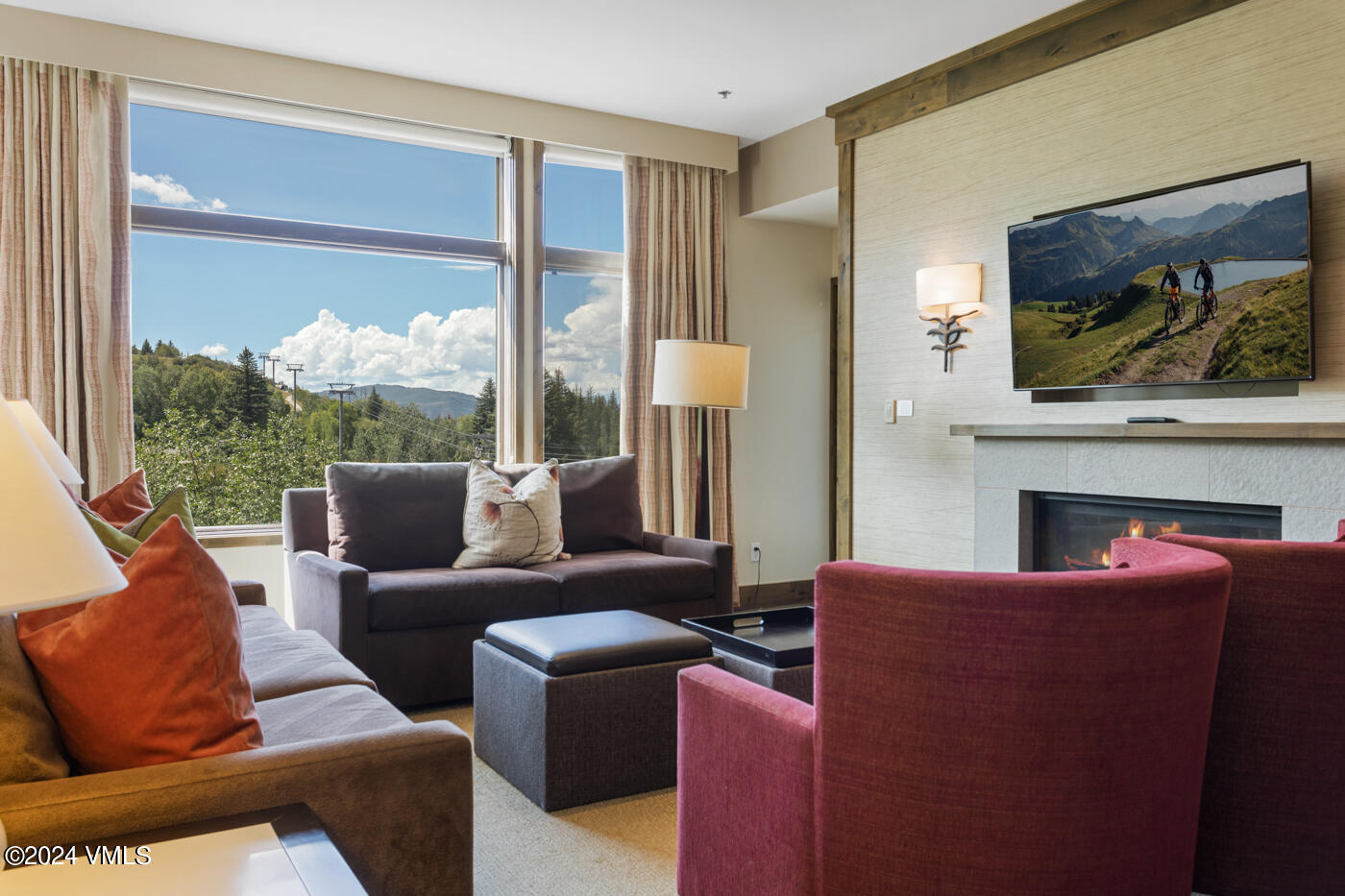 a living room with furniture a large window and a flat screen tv