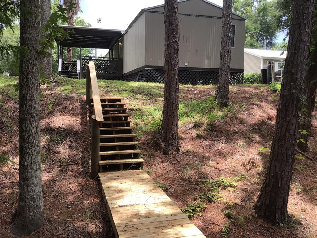 a view of a house with backyard and trees