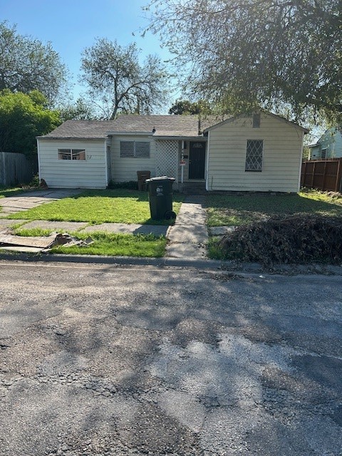 a view of a house with a yard and a large tree