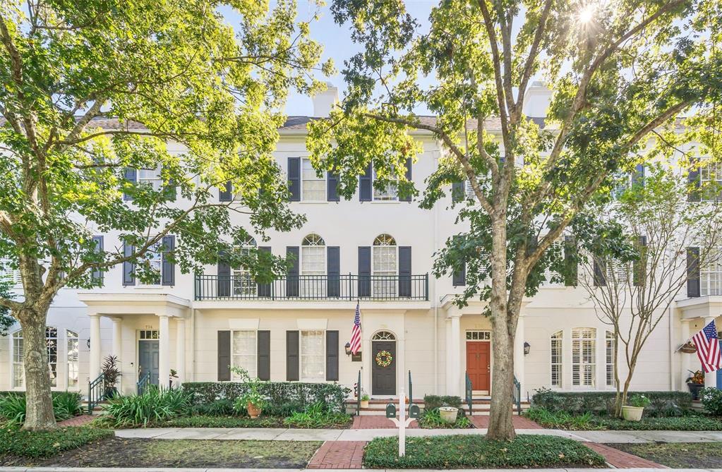 front view of a white house with a tree