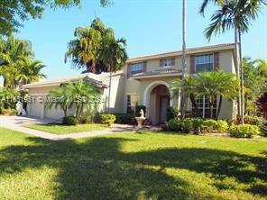 a view of a house with a yard and palm trees