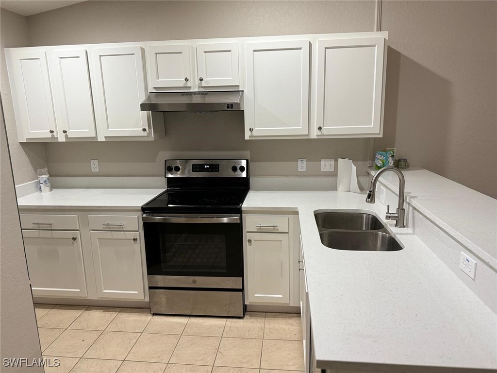 a kitchen with white cabinets and appliances