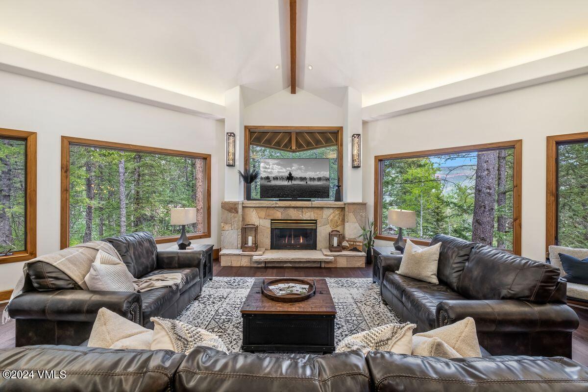 a living room with furniture a fireplace and a large window