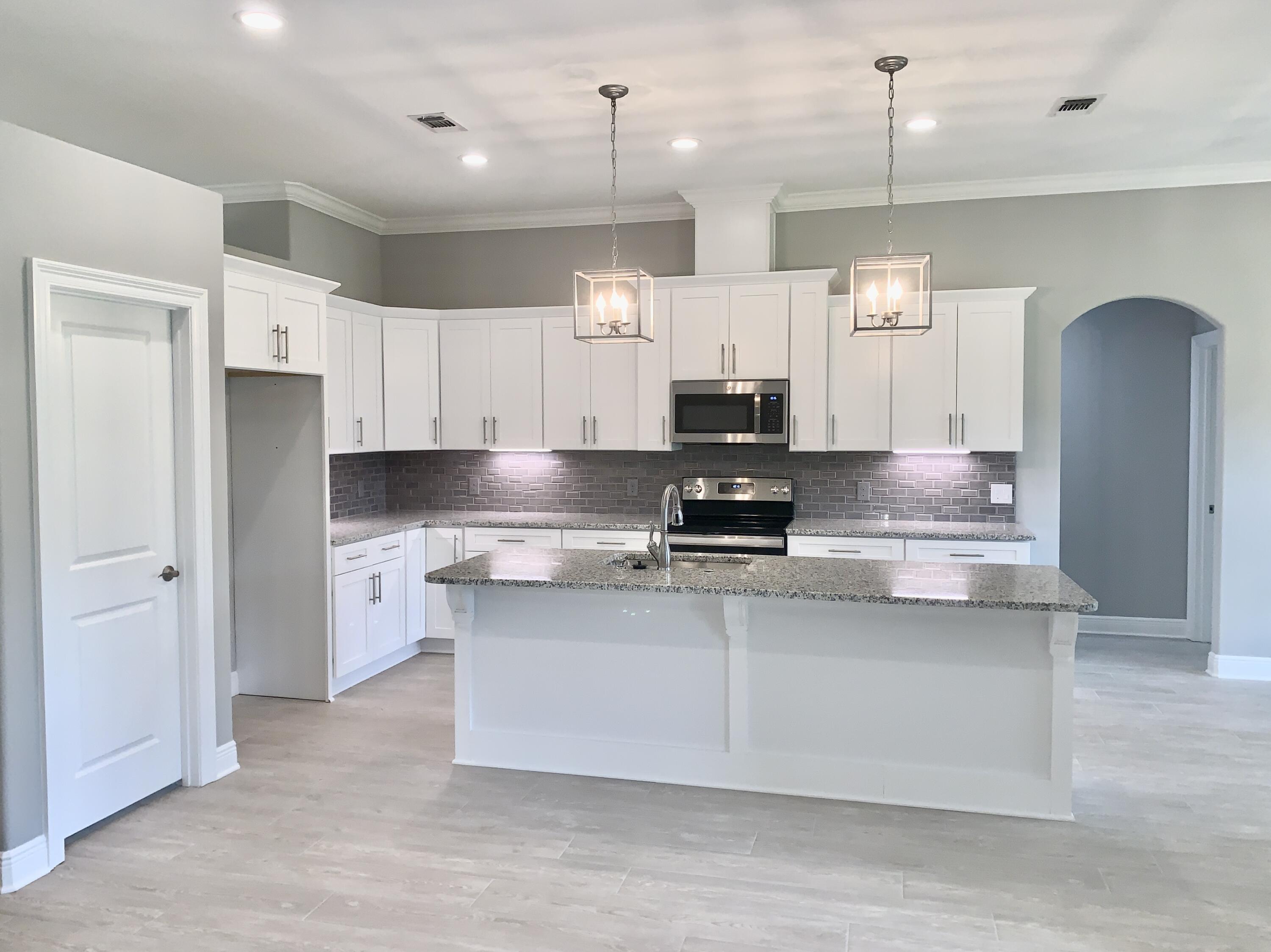 a kitchen with stainless steel appliances granite countertop a sink a stove and a refrigerator