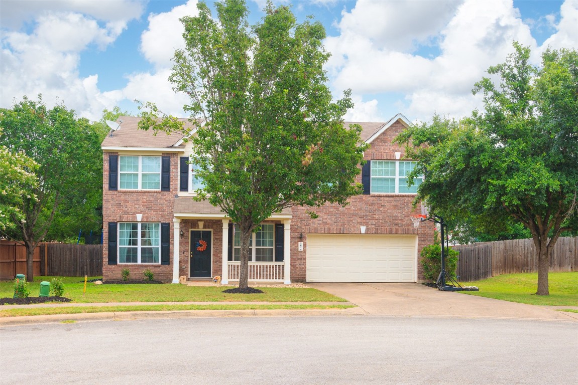 a front view of a house with a garden and trees