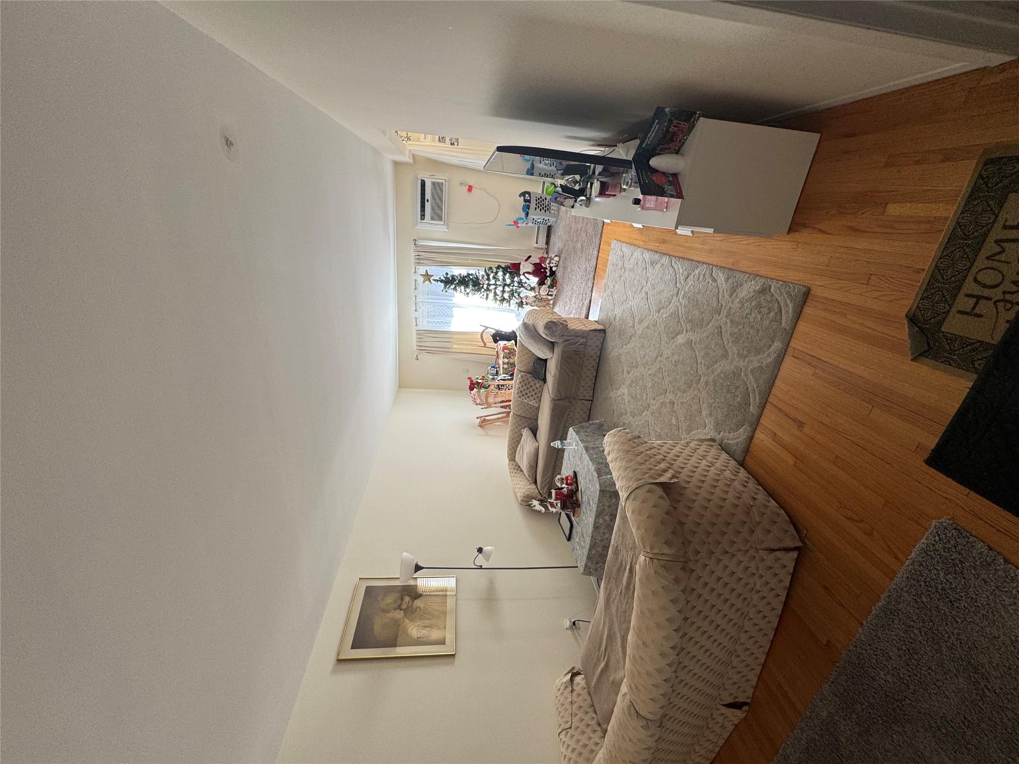 Living room featuring an AC wall unit and hardwood / wood-style flooring