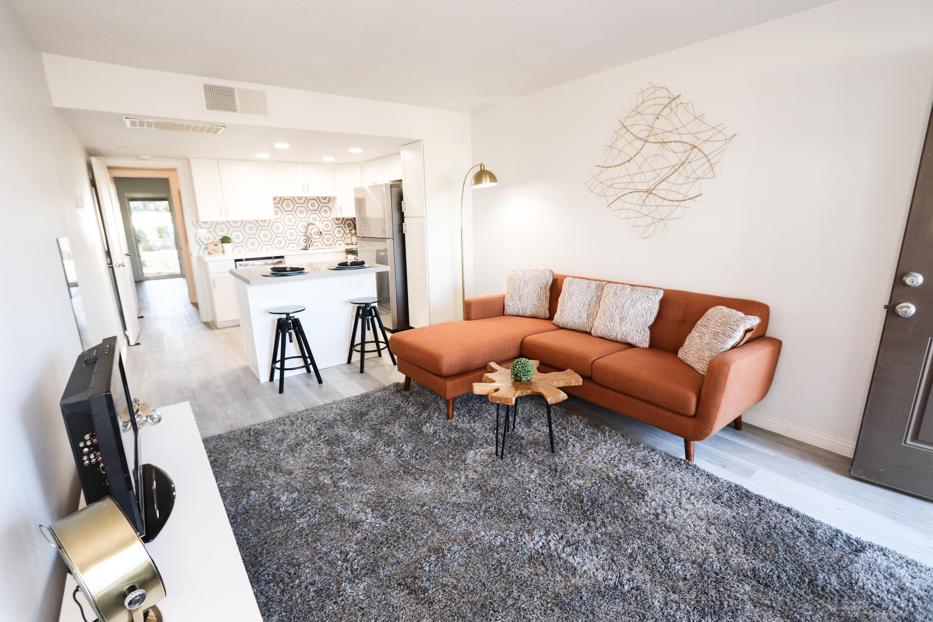 a living room with furniture a rug and a table