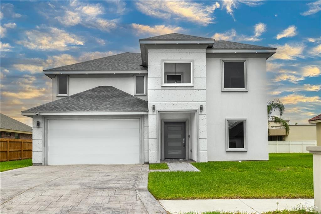 View of front of property with a garage and a front lawn